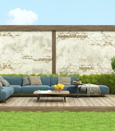 Modern blue sofa in a garden on deck floor